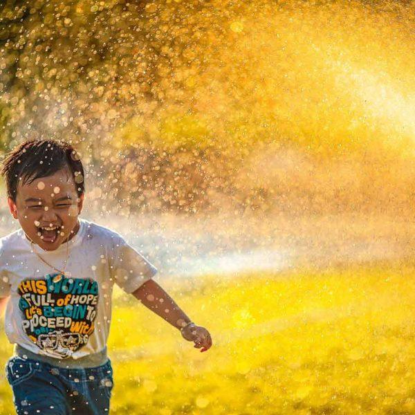 Outdoor Summer Activities For Kids - Kids Running Through A Sprinkler